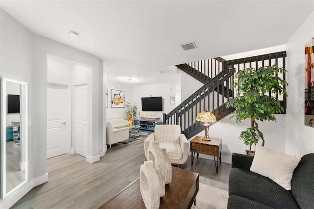 549 NE 206th Ln, Miami, FL 33179 - living room featuring baseboards, wood finished floors, visible vents, and stairway