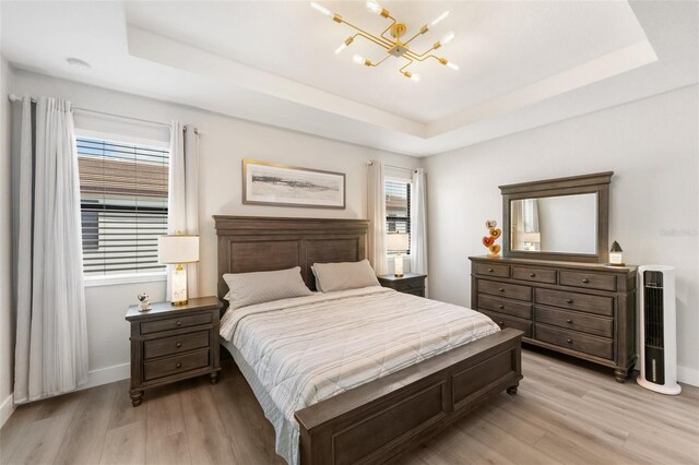 549 NE 206th Ln, Miami, FL 33179 - bedroom with a raised ceiling, light wood-type flooring, baseboards, and an inviting chandelier