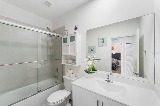 549 NE 206th Ln, Miami, FL 33179 - ensuite bathroom featuring toilet, visible vents, enclosed tub / shower combo, vanity, and connected bathroom
