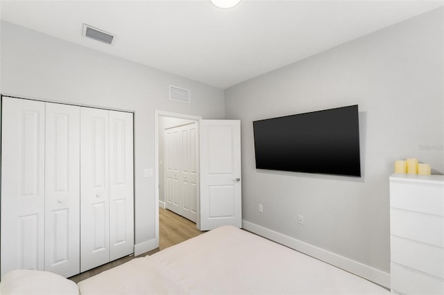 549 NE 206th Ln, Miami, FL 33179 - bedroom featuring baseboards, wood finished floors, visible vents, and a closet