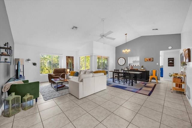 living area with light tile patterned floors, visible vents, and ceiling fan with notable chandelier