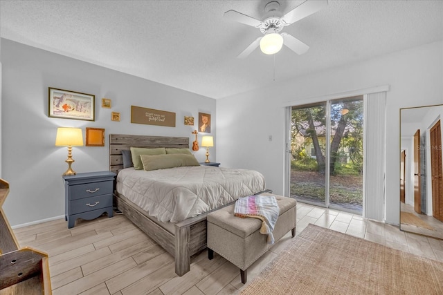 bedroom featuring access to outside, a textured ceiling, wood finish floors, and ceiling fan