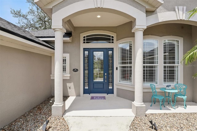 entrance to property featuring stucco siding