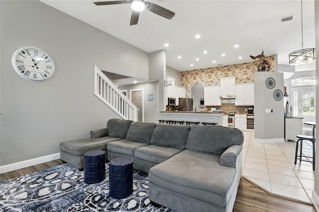 living area with ceiling fan, stairs, recessed lighting, baseboards, and light wood-type flooring