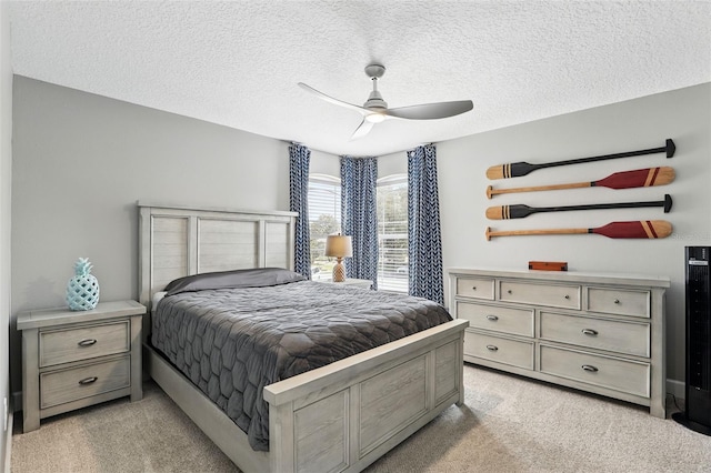 bedroom with light carpet, a textured ceiling, and a ceiling fan
