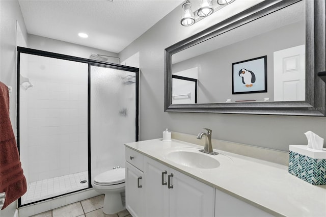 full bathroom with a stall shower, vanity, tile patterned floors, toilet, and a textured ceiling