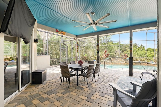 sunroom featuring a ceiling fan and outdoor dining space