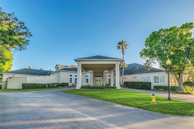 view of front facade with french doors, a front lawn, and stucco siding