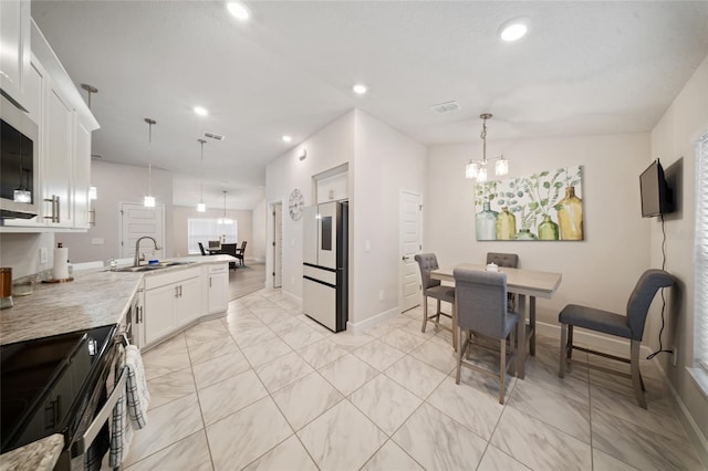 8137 Merano Ave, Fort Pierce, FL 34951 - kitchen with a peninsula, recessed lighting, a chandelier, a sink, and fridge