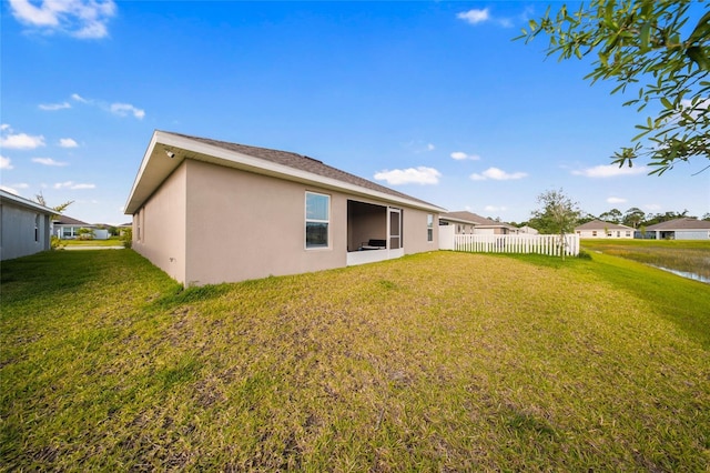 8137 Merano Ave, Fort Pierce, FL 34951 - rear view of property with a yard, stucco siding, fence, and a water view