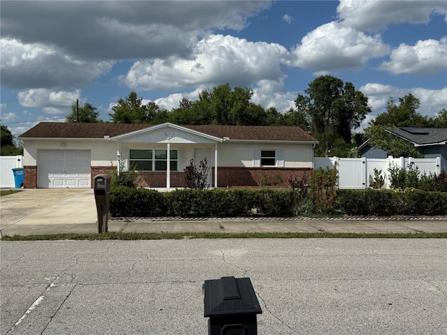 ranch-style home featuring a garage, brick siding, fence, and a gate