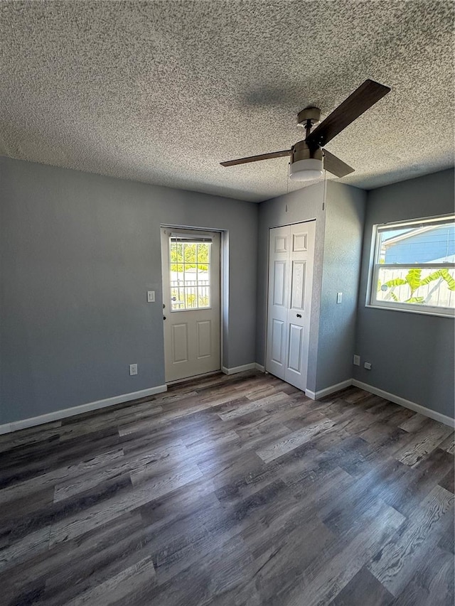 unfurnished bedroom featuring a closet, baseboards, ceiling fan, a textured ceiling, and wood finished floors