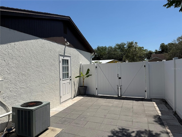 view of patio featuring fence, a gate, and central air condition unit