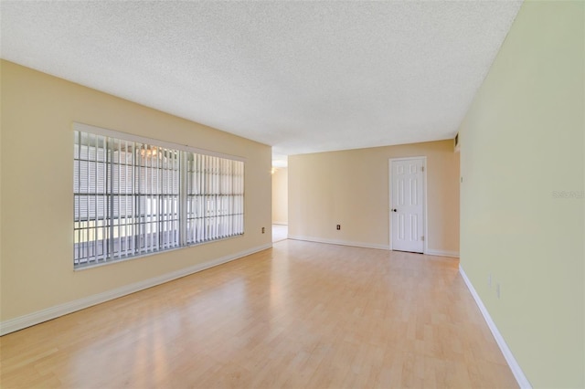 1048 Plantation Dr Unit 12, Kissimmee, FL 34741 - spare room featuring light wood-type flooring, baseboards, and a textured ceiling
