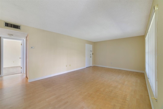1048 Plantation Dr Unit 12, Kissimmee, FL 34741 - unfurnished room featuring visible vents, baseboards, light wood-style floors, and a textured ceiling
