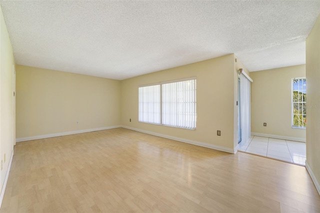 1048 Plantation Dr Unit 12, Kissimmee, FL 34741 - spare room with light wood-style flooring, a textured ceiling, and baseboards