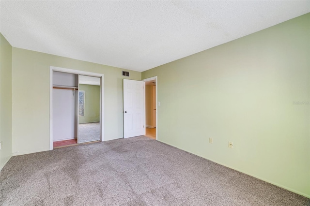 1048 Plantation Dr Unit 12, Kissimmee, FL 34741 - unfurnished bedroom featuring baseboards, a closet, a textured ceiling, visible vents, and carpet