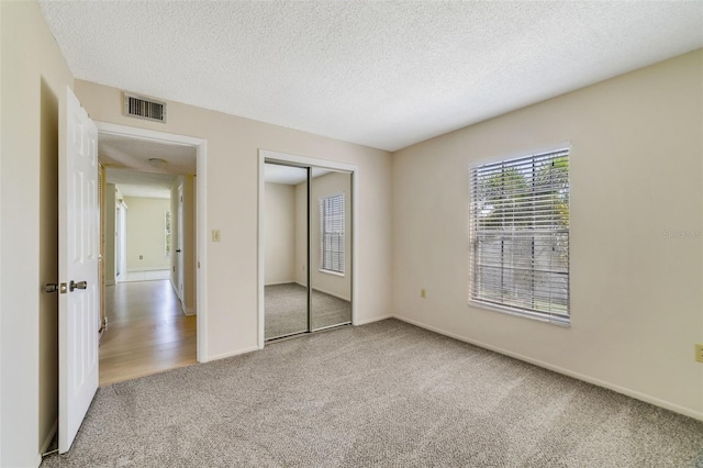 1048 Plantation Dr Unit 12, Kissimmee, FL 34741 - unfurnished bedroom with a textured ceiling, a closet, visible vents, carpet floors, and baseboards