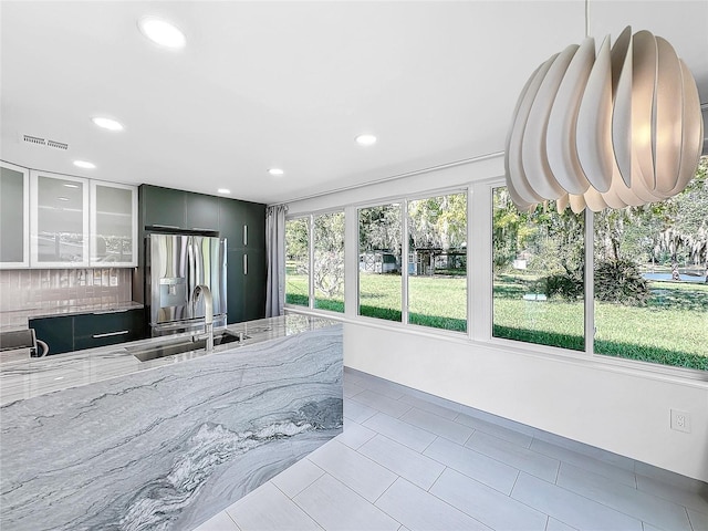 407 Sheryl Dr, Deltona, FL 32738 - kitchen featuring a sink, stainless steel fridge, light stone countertops, visible vents, and recessed lighting