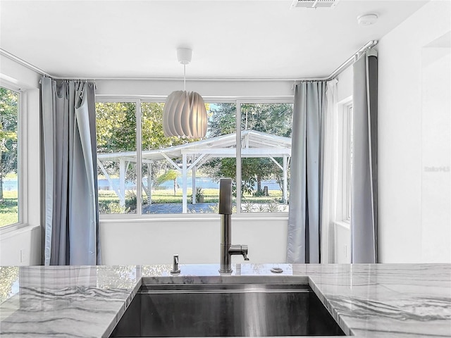 407 Sheryl Dr, Deltona, FL 32738 - room details with light stone countertops, visible vents, a sink, and hanging light fixtures