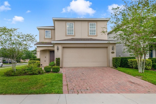 traditional home with an attached garage, stucco siding, a front lawn, and decorative driveway
