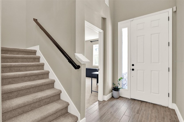 entryway featuring stairs, baseboards, and wood finished floors
