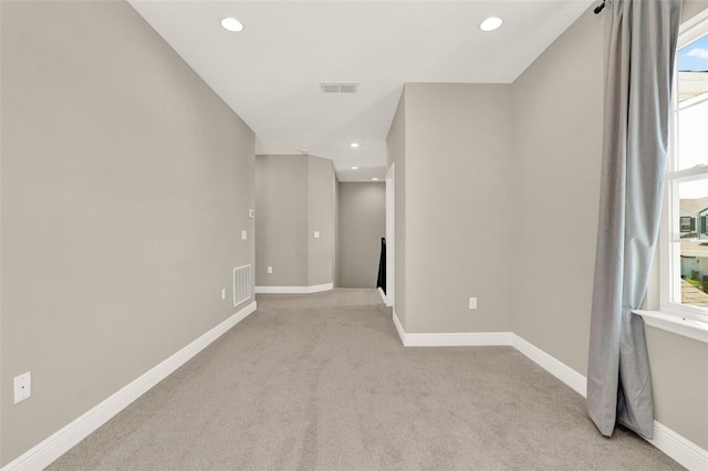 unfurnished room featuring light carpet, baseboards, visible vents, and recessed lighting