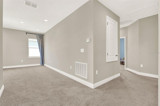 spare room featuring carpet flooring, baseboards, and visible vents