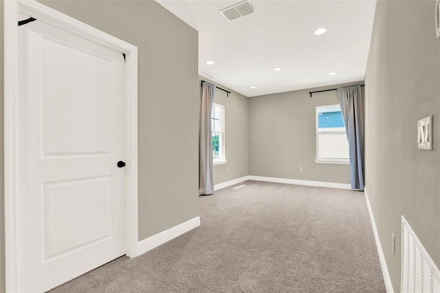 empty room with recessed lighting, carpet, visible vents, and baseboards