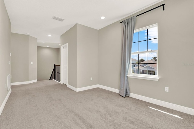 spare room with recessed lighting, carpet, visible vents, and baseboards