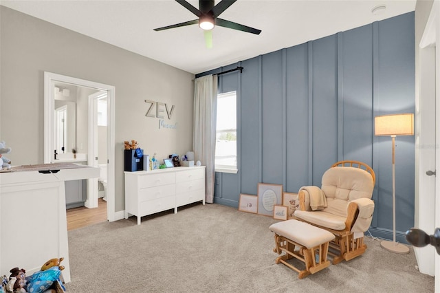 sitting room with carpet flooring and ceiling fan