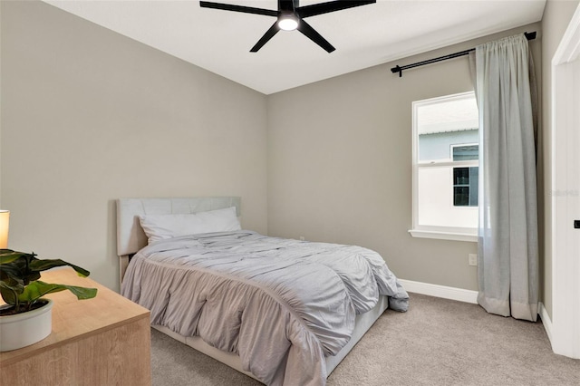 bedroom featuring ceiling fan, light colored carpet, and baseboards