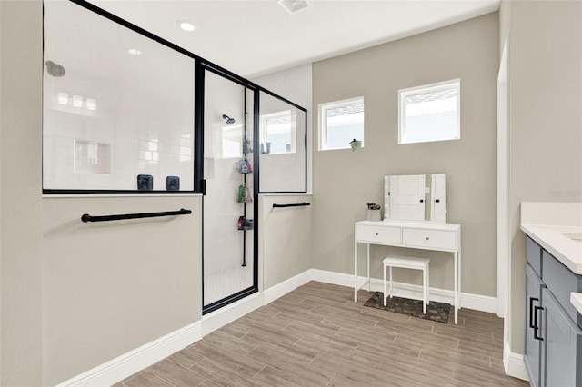 bathroom with baseboards, a stall shower, and wood finished floors