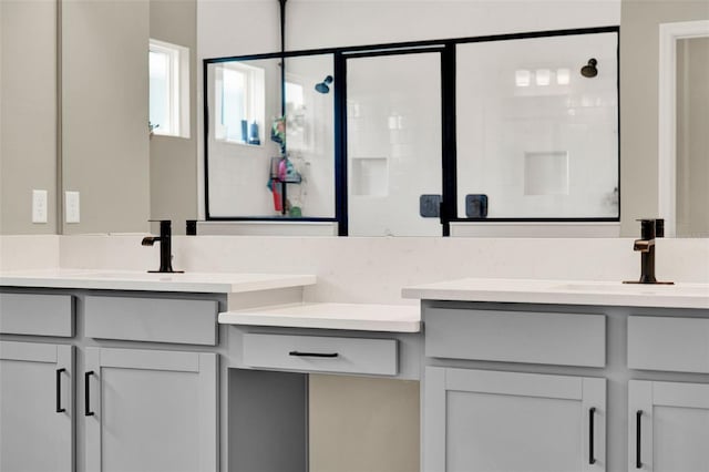 full bathroom featuring a shower stall, double vanity, and a sink