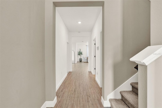 hall with recessed lighting, stairway, light wood-style floors, and baseboards