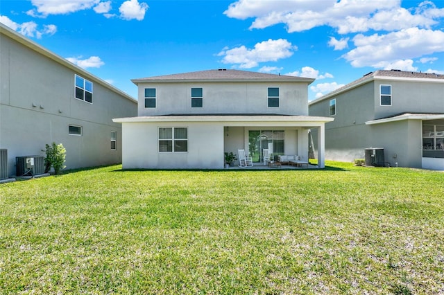 rear view of property featuring central AC, a yard, and stucco siding