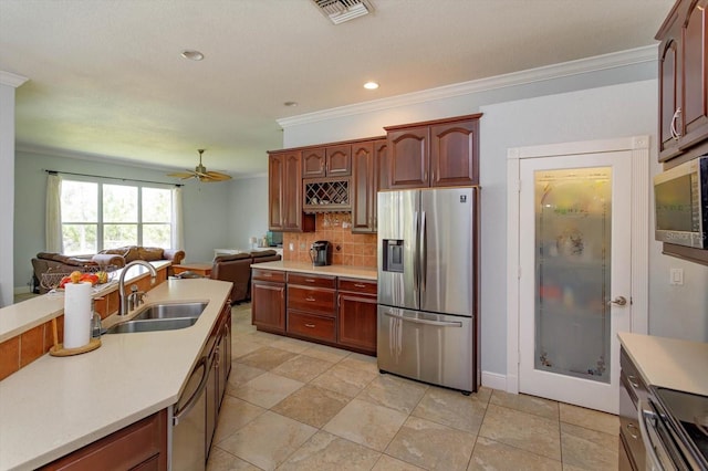 4556 Serna Ave, Malabar, FL 32950 - kitchen with stainless steel appliances, ceiling fan, crown molding, decorative backsplash, and light countertops