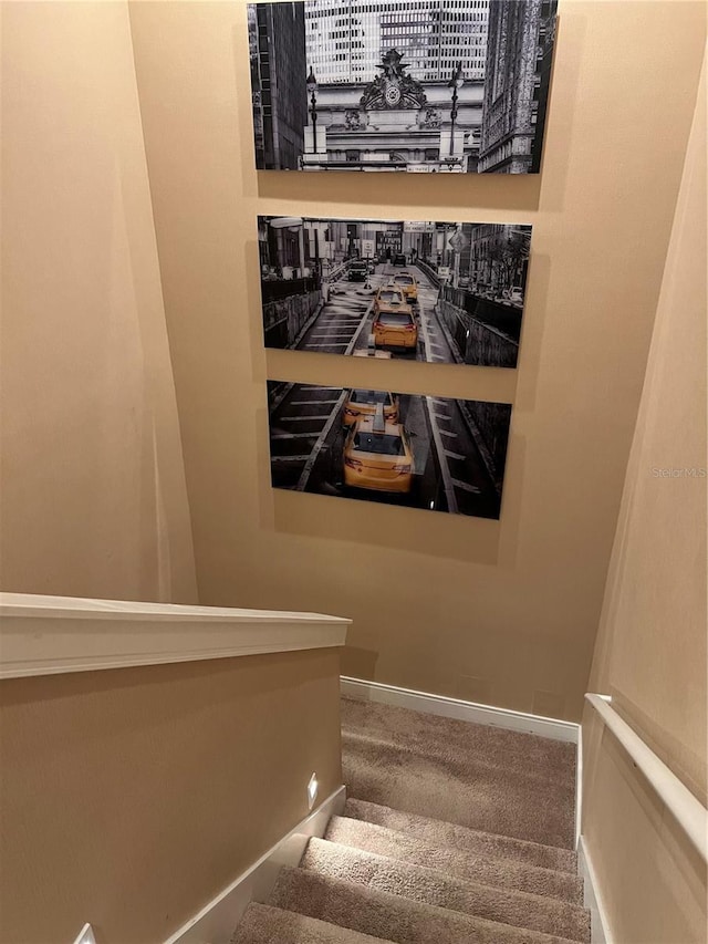 stairs featuring baseboards and carpet