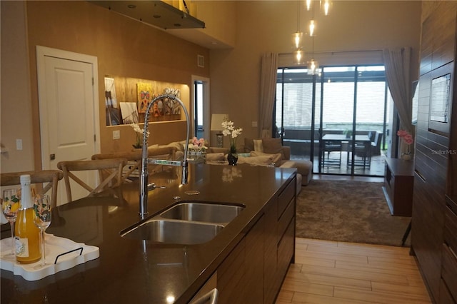 kitchen with visible vents, modern cabinets, a sink, open floor plan, and light wood-style flooring
