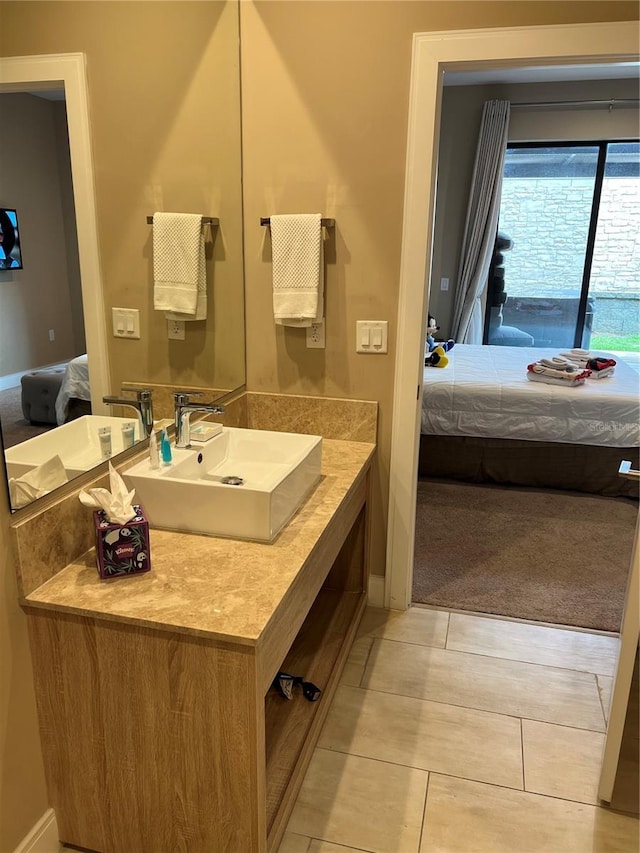 ensuite bathroom with baseboards, vanity, tile patterned floors, and connected bathroom