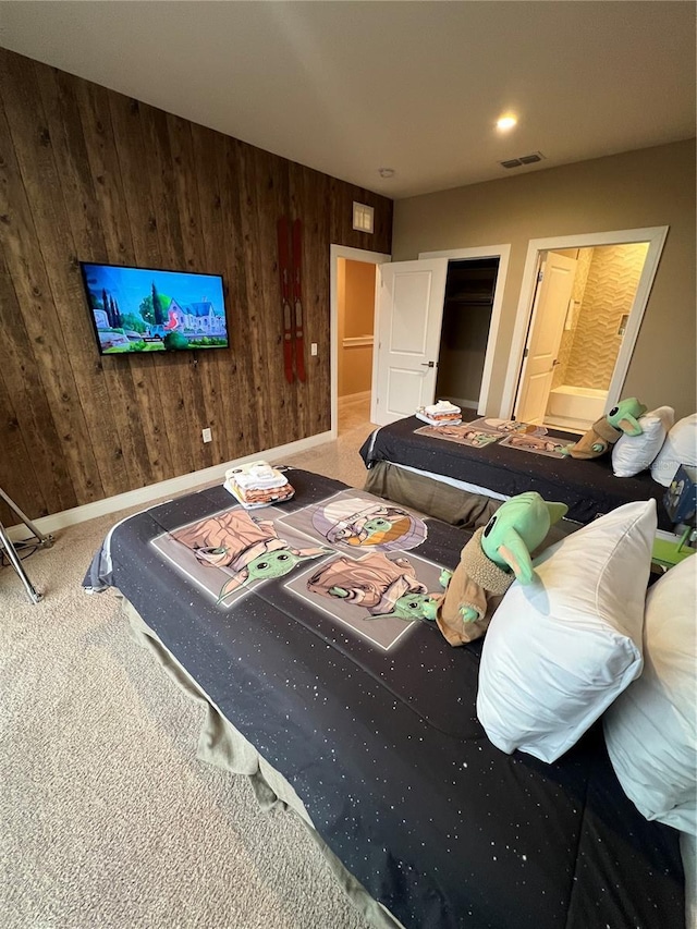 bedroom with wooden walls, baseboards, carpet flooring, and visible vents