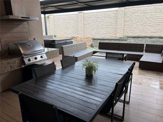 wooden terrace featuring outdoor lounge area, a hot tub, outdoor dining space, and area for grilling