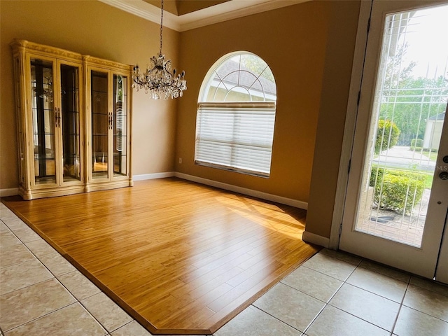 702 Palenci Ct, Winter Springs, FL 32708 - unfurnished dining area with light wood finished floors, a notable chandelier, baseboards, and crown molding