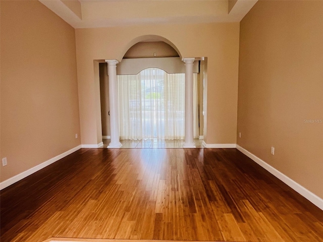 702 Palenci Ct, Winter Springs, FL 32708 - unfurnished room with arched walkways, ornate columns, baseboards, and wood finished floors