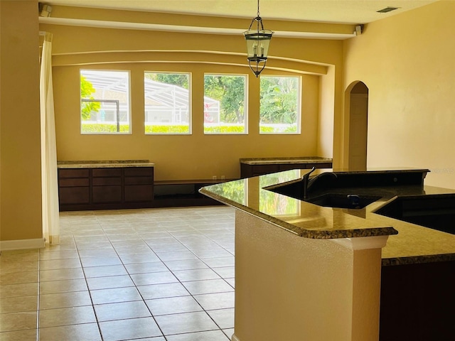 702 Palenci Ct, Winter Springs, FL 32708 - kitchen with light tile patterned flooring, visible vents, arched walkways, pendant lighting, and a sink