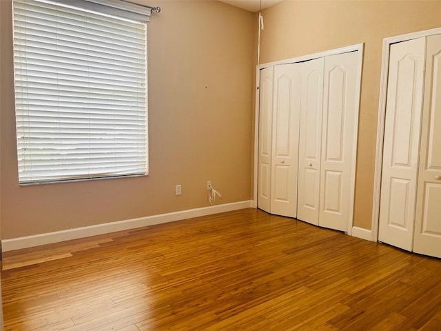 702 Palenci Ct, Winter Springs, FL 32708 - unfurnished bedroom featuring baseboards, multiple closets, and wood finished floors