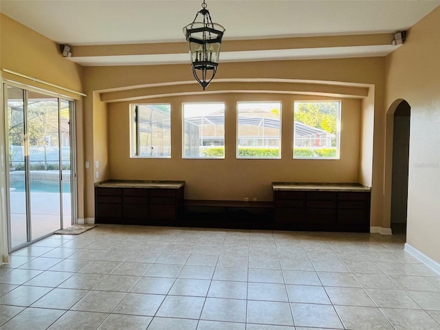 702 Palenci Ct, Winter Springs, FL 32708 - spare room featuring light tile patterned floors, baseboards, arched walkways, and beam ceiling