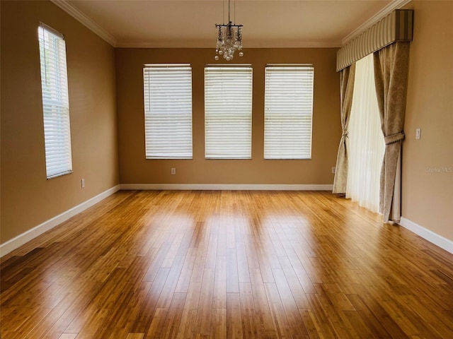 702 Palenci Ct, Winter Springs, FL 32708 - spare room featuring plenty of natural light, a notable chandelier, crown molding, and wood finished floors