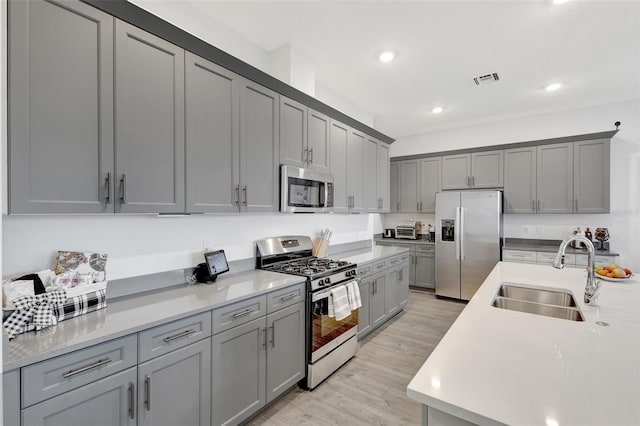 15865 Key Biscayne Ln, Loxahatchee, FL 33470 - kitchen featuring appliances with stainless steel finishes, a sink, gray cabinetry, light wood-type flooring, and recessed lighting