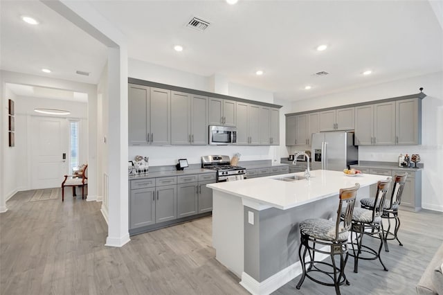 15865 Key Biscayne Ln, Loxahatchee, FL 33470 - kitchen with gray cabinetry, stainless steel appliances, a sink, a kitchen bar, and recessed lighting